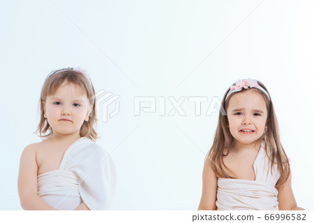 a little girls grimaces against a white 66996582