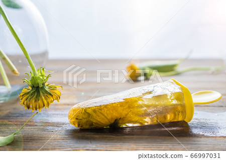 spring ice cream with Dandelions flowers, wooden background 66997031