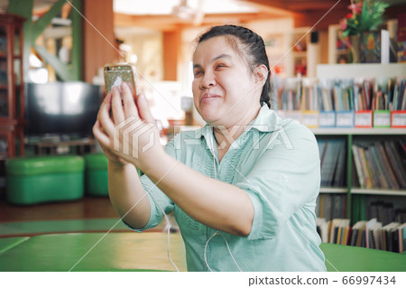 Asian young blind woman taking selfie using smart phone Asian young blind woman taking selfie using smart phone 66997434