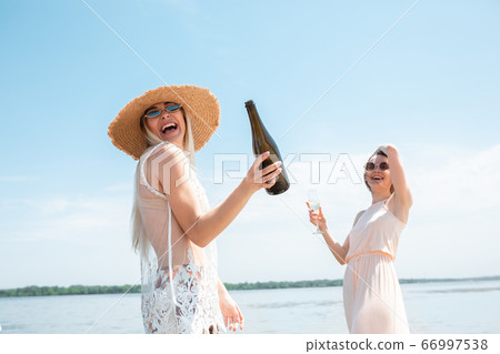Seasonal feast at beach resort. Close up woman celebrating, resting, having fun on the beach in sunny summer day 66997538