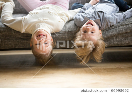 Portrait of siblings boy and girl laughing lying upside down 66998692