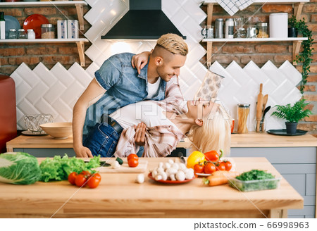 Happy young couple in love dancing in kitchen at home and having fun 66998963