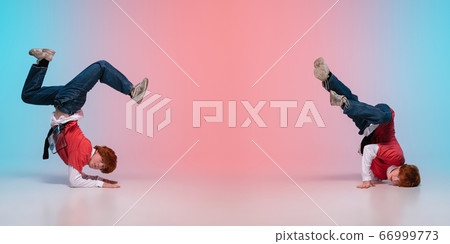 Boy dancing hip-hop in stylish clothes on gradient background at dance hall in neon light. 66999773