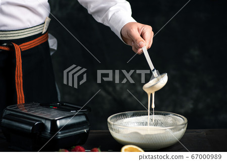 Chef mixing waffle dough in a bowl 67000989