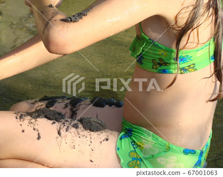 child puts river mud on his body on the river Bank child puts river mud on his body on the river Bank 67001063