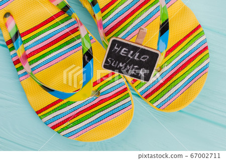 Fashion beach flip flops with little chalkboard on azure background. Fashion beach flip flops with little chalkboard on azure background. 67002711