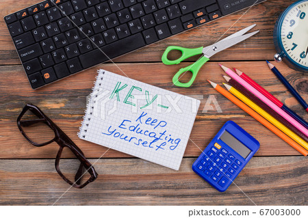 Keep educating yourself note and school accessories on wood. Keep educating yourself note and school accessories on wood. 67003000