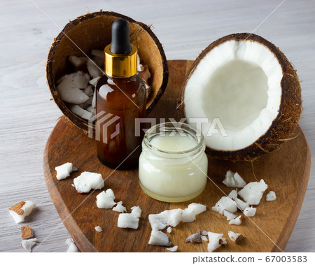 Coconut oil and fresh coconuts on the wooden table Coconut oil and fresh coconuts on the wooden table 67003583