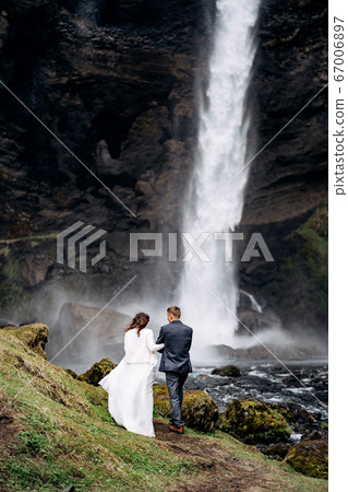 Destination Iceland wedding, near Kvernufoss waterfall. Wedding couple goes to the waterfall. 67006897