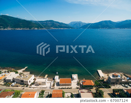 Aerial photo from the drone, a street with houses on the coast of Kotor Bay in Montenegro. Aerial photo from the drone, a street with houses on the coast of Kotor Bay in Montenegro. 67007124