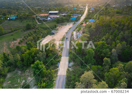 Aerial view of rural road cross green forest and Aerial view of rural road cross green forest and 67008234