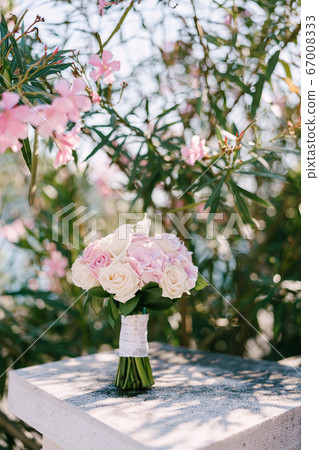 bridal bouquet of rose and cream roses and calla lilies white stone railway near the blooming rose oleander bush bridal bouquet of rose and cream roses and calla lilies white stone railway near the blooming rose oleander bush 67008333