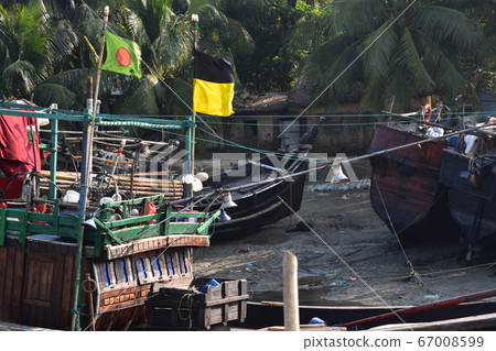 Cox's Bazar in Bangladesh Coastal fishing village and fishing boats on a traditional traditional hull and Bangladesh flag Cox's Bazar in Bangladesh Coastal fishing village and fishing boats on a traditional traditional hull and Bangladesh flag 67008599