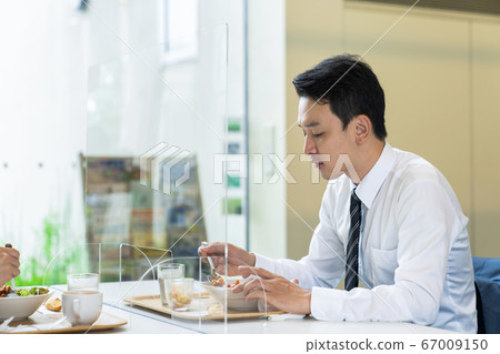 男人在丙烯酸隔板之間進食 男人在丙烯酸隔板之間進食 67009150