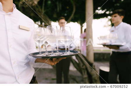 The waiter spreads cold water with lemon on the tray. 67009252