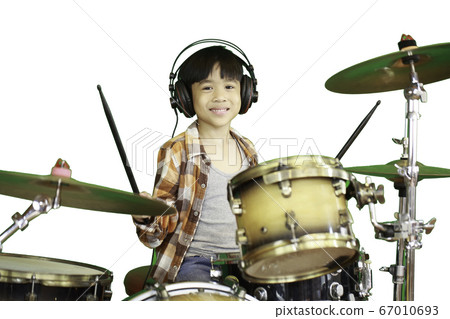 A cute Asian boy is enjoying playing the drums in a music classroom. A cute Asian boy is enjoying playing the drums in a music classroom. 67010693