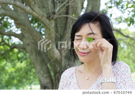 A middle woman who takes a walk to enjoy early summer A middle woman who looks good in nature 67010749