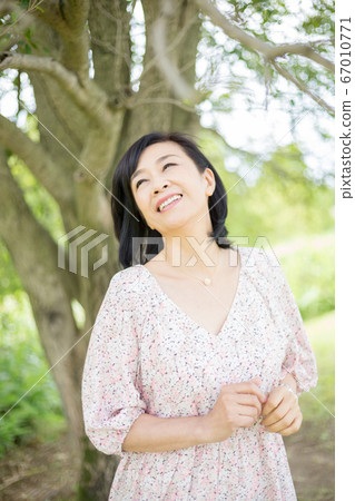 A middle woman who takes a walk to enjoy early summer A middle woman who looks good in nature 67010771