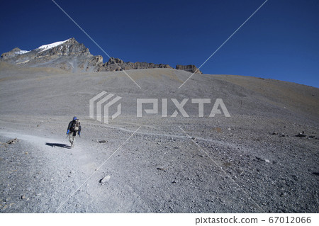 Solo trekker on mountain, enjoying in nature 67012066