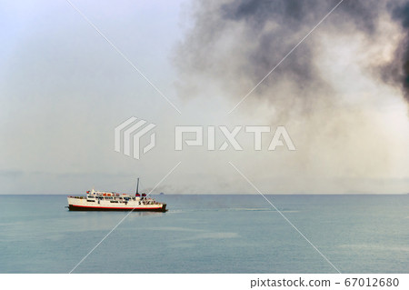 Exhaust pipe of ferry boat with black thick smoke coming out and sky with clouds on background. Air pollution. Exhaust pipe of ferry boat with black thick smoke coming out and sky with clouds on background. Air pollution. 67012680