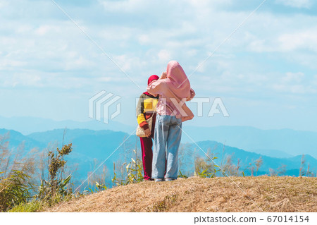 Back view of Muslim women wearing a Muslim dress and hijab enjoy on the highest point and the beautiful view landscape in morning at Elephant Hills  View Point are located in Thong Pha Phum Kanchanabu 67014154