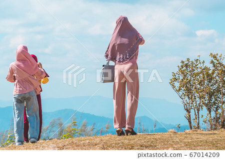 Back view of Muslim women wearing a Muslim dress and hijab enjoy on the highest point and the beautiful view landscape in morning at Elephant Hills View Point are located in Thong Pha Phum Kanchanabu Back view of Muslim women wearing a Muslim dress and hijab enjoy on the highest point and the beautiful view landscape in morning at Elephant Hills View Point are located in Thong Pha Phum Kanchanabu 67014209
