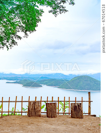 Natural chair made from wooden log for lookout point with resting . Beautiful scenery of nature with a large reservoir above the Srinagarind Dam at Rai Ya Yam view point in Kanchanaburi, Thailand. 67014518