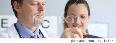Male and female doctors carefully look at an x-ray 67015177