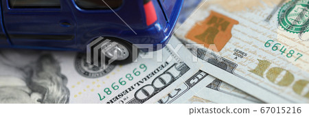 Blue toy minivan car costs on scattered dollars 67015216