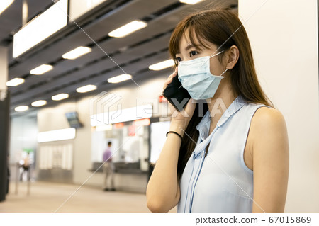 business woman wearing face mask at train station business woman wearing face mask at train station 67015869