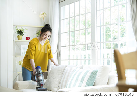 Young woman cleaning the sofa Young woman cleaning the sofa 67016146