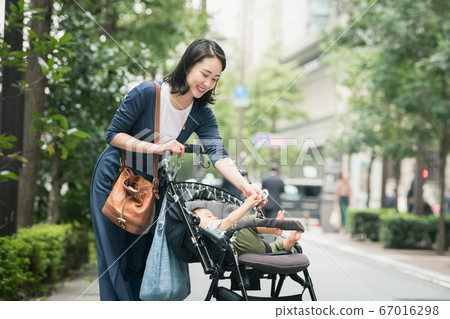 媽媽走路和逛街與嬰兒推車的形象 67016298