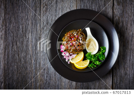 Pickled wakame salad with red onion, and lemon 67017813