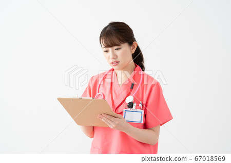 Young female doctor wearing a white background pink medical clothes and looking at the diagnosis table (questionnaire) and thinking 67018569