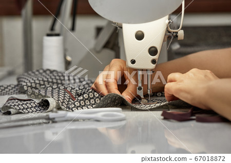 girl seamstress sew on the sewing machine 67018872