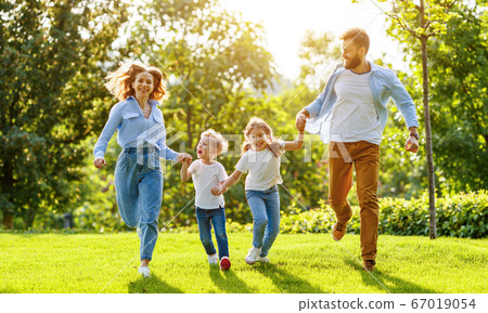 Happy family playing together in park. 67019054