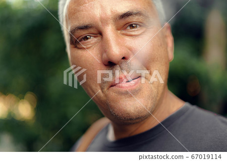 Caucasian mature middle aged man smoking cigarette outdoors. Nicotine addiction. Copy space 67019114