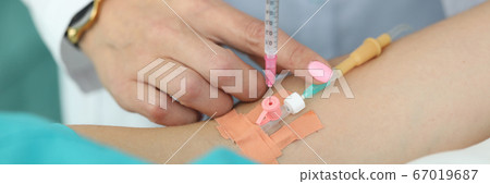 Female doctor injects medicine into patients vein 67019687