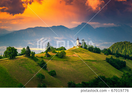 Alpine sunset landscape with Saint Primoz church, near Jamnik, Slovenia 67019776