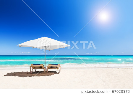 Beach chairs with umbrella and beautiful sand 67020573