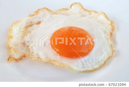 Fried egg on a white plate Fried egg on a white plate 67021094