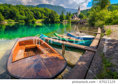 Spectacular alpine lake and colorful canoes, Lake Bohinj, Slovenia, Europe Spectacular alpine lake and colorful canoes, Lake Bohinj, Slovenia, Europe 67021129