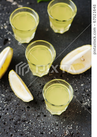 Italian traditional liqueur limoncello with lemon 67021648
