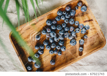 Fresh blueberry in a wooden tray on a linen light cloth. Healthy eating and Summer concept. Fresh blueberry in a wooden tray on a linen light cloth. Healthy eating and Summer concept. 67021743