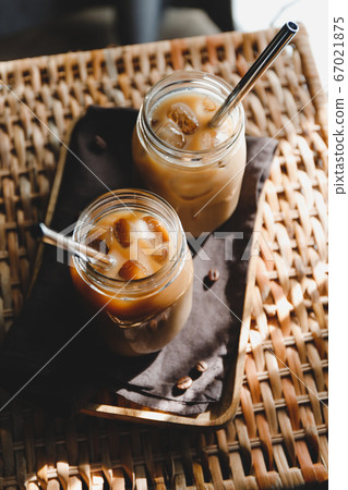 Top view of a glass jar with iced latte on a rattan table Top view of a glass jar with iced latte on a rattan table 67021875