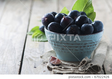 Red sweet figs on the wooden table 67022426
