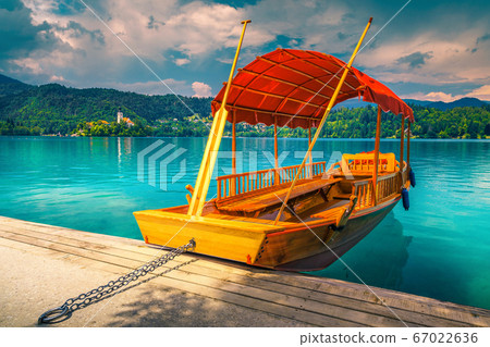 Wooden Pletna boat on the lake Bled with small island Wooden Pletna boat on the lake Bled with small island 67022636