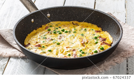 Omelette with prosciutto peas and herbs in ceramic Omelette with prosciutto peas and herbs in ceramic 67024337