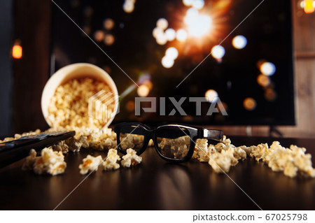 Cinema at home with popcorn at the table. Cinema at home with popcorn at the table. 67025798