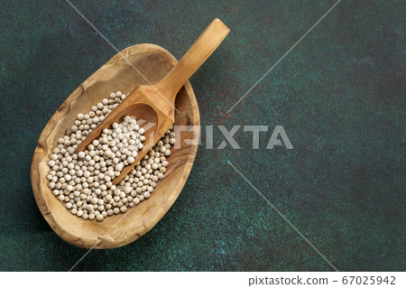 White peppercorn in wooden bowl White peppercorn in wooden bowl 67025942